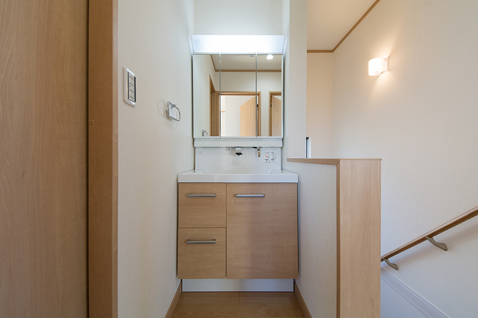 ブラウンの洗面化粧台がナチュラルな雰囲気の空間を演出する2階洗面スペース。
