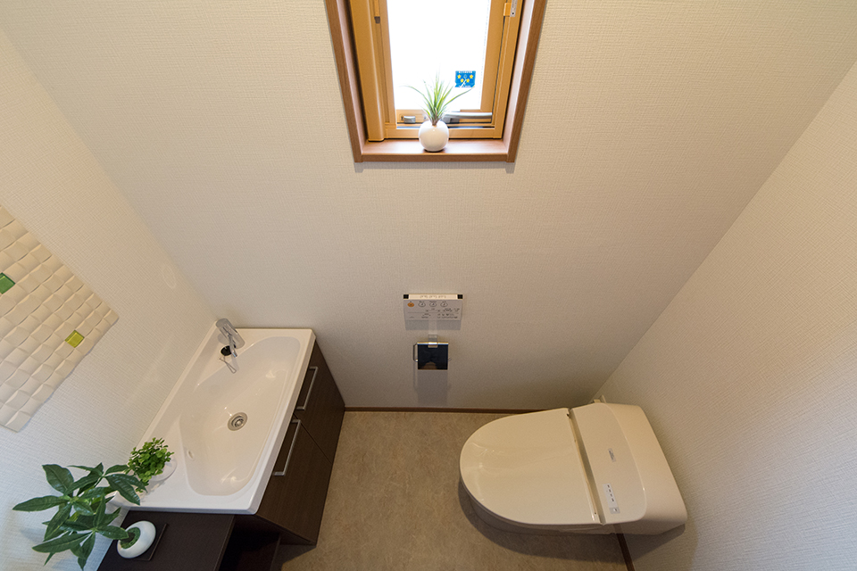2階トイレ－見た目もすっきりとしたタンクレストイレを使用。壁にはエコカラットをあしらいました。