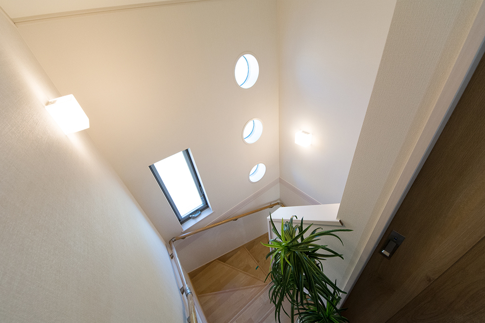 丸型のFIX窓が印象的な明るく開放感のある階段スペース。