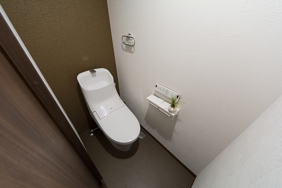 白を基調とした清潔感のある1階トイレ。アクセントクロスがナチュラルな印象を与えます。