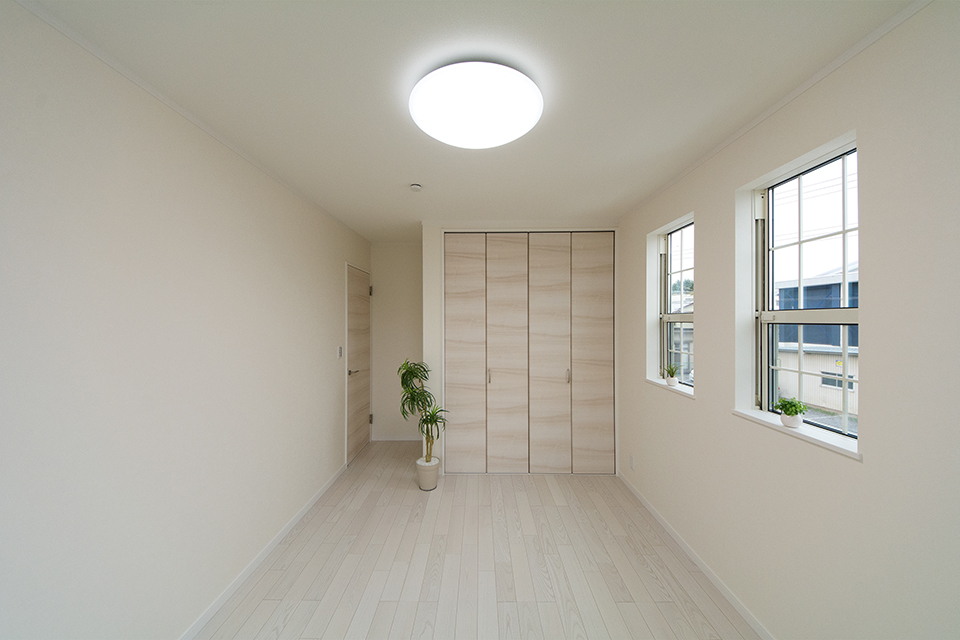 2階洋室。ホワイトアッシュのフローリングとイタリアンウォルナット調の建具が洗練された空間を演出。