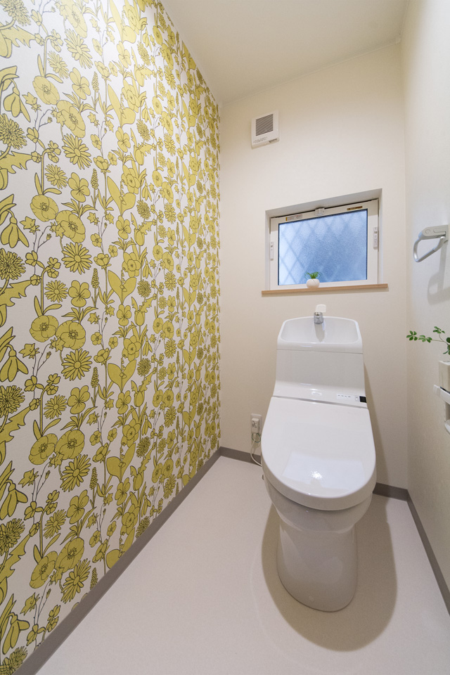 白を基調とした清潔感のある1階トイレ。アクセントクロスが印象的です。