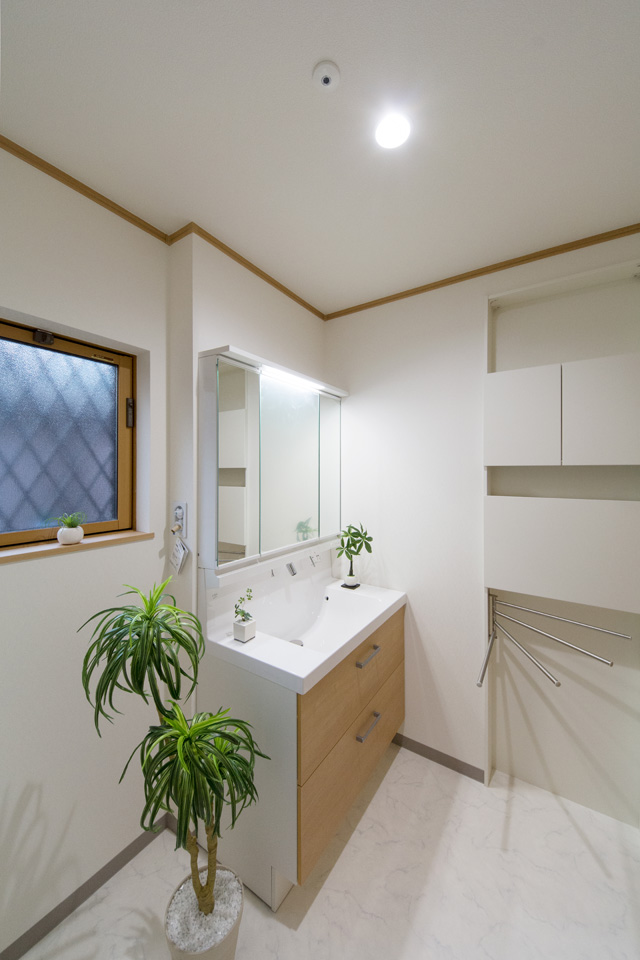 ブラウンの洗面化粧台がナチュラルな雰囲気の空間を演出する1階サニタリールーム。