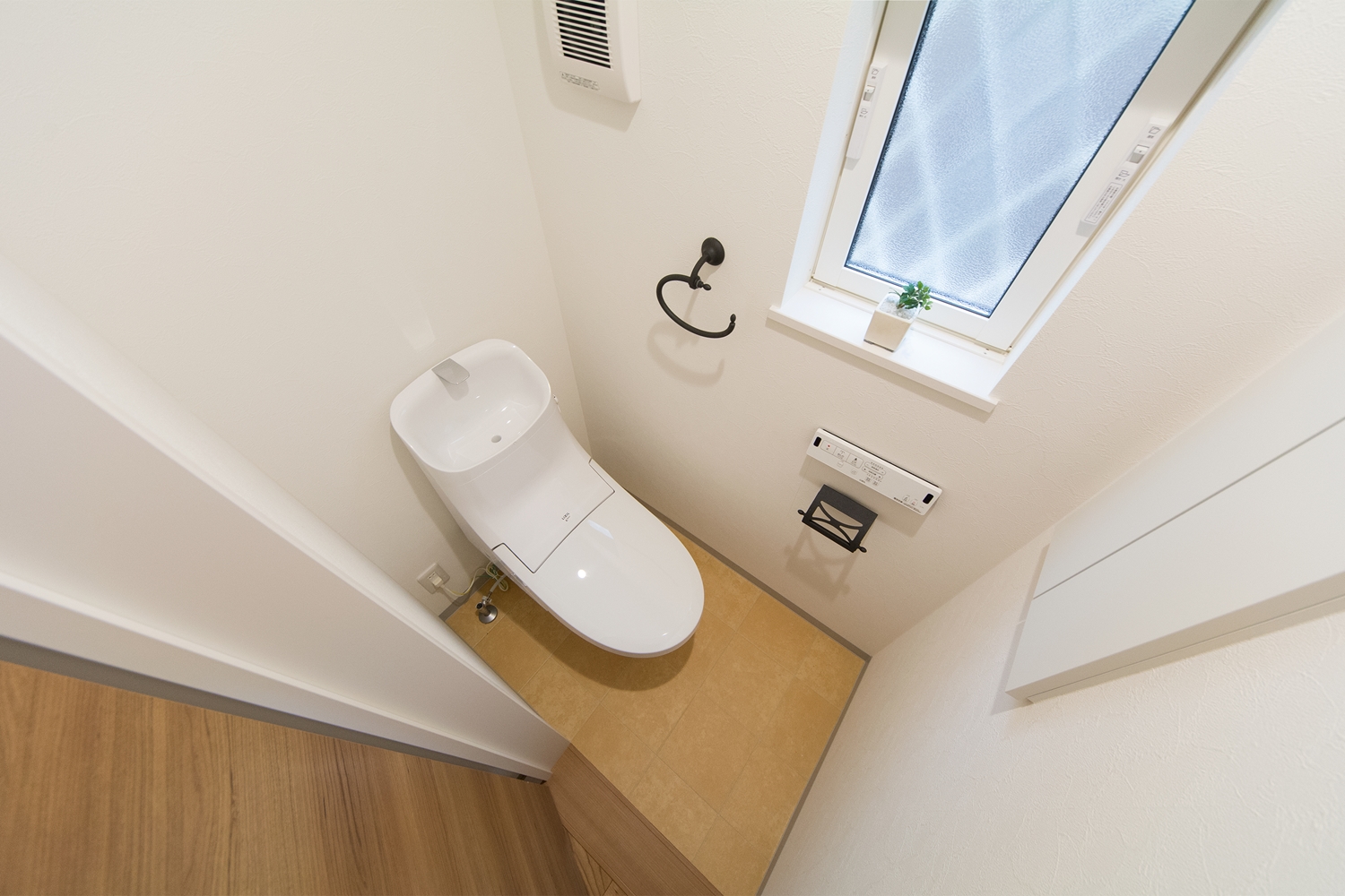 白を基調とした清潔感のある1階トイレ。アイアン調のタオル掛とペーパー ホルダーが印象的です。