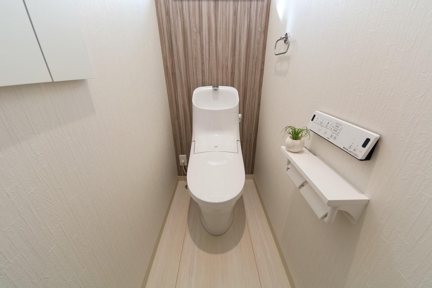 白を基調とした清潔感のある2階トイレ。木目調のアクセントクロスがワンポイントでオシャレです。