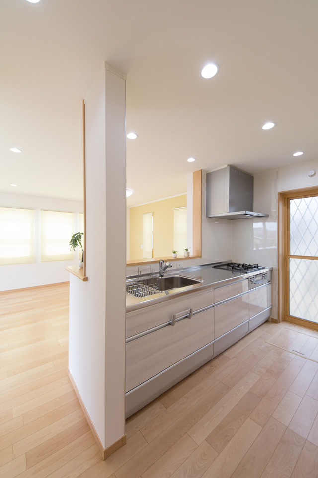 1Fキッチン扉は、光沢のある木目調ホワイトで清潔感のある空間に。