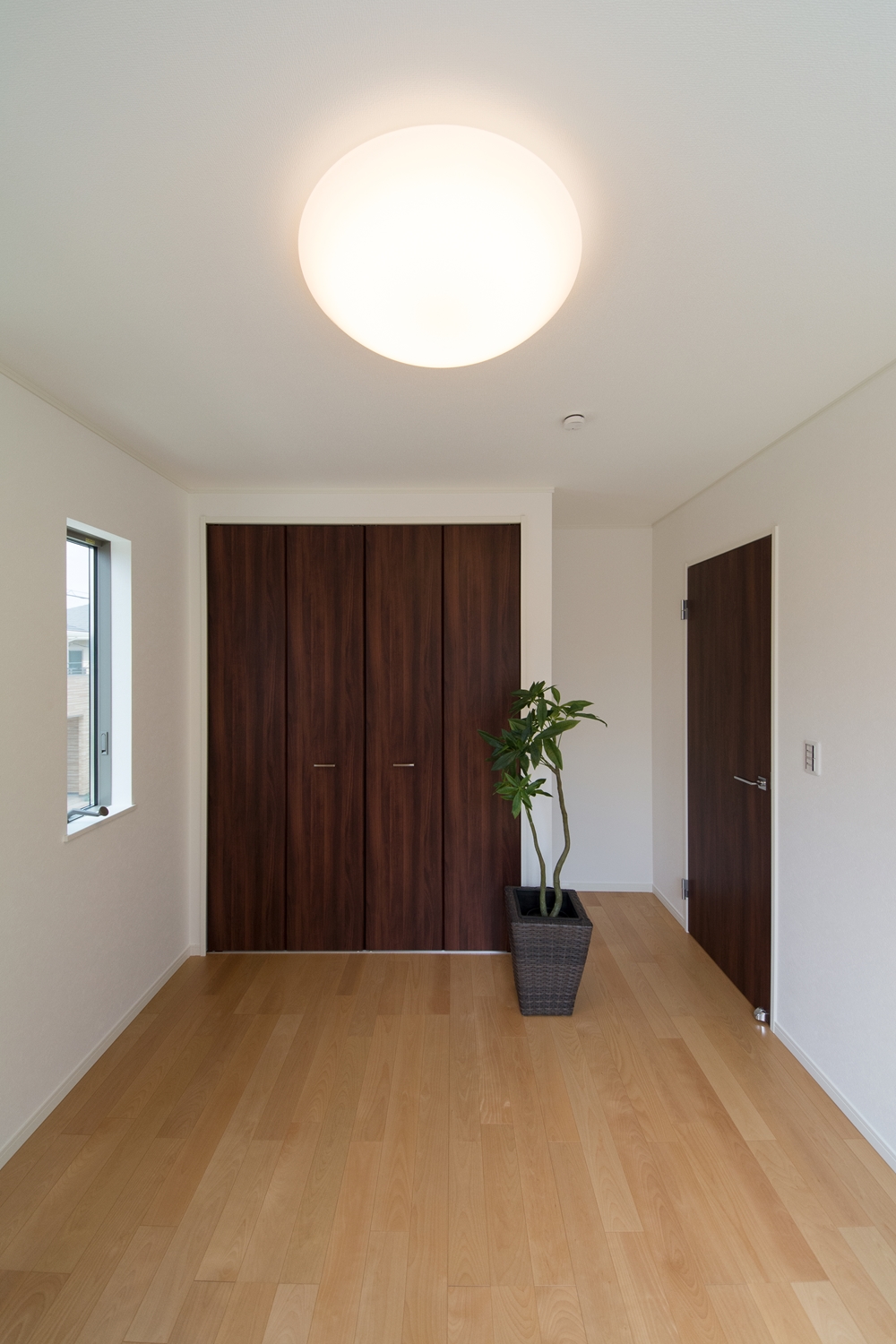 穏やかな木目のバーチを床材にダークブラウンの建具を合わせた、ナチュラルな空間の2階洋室。