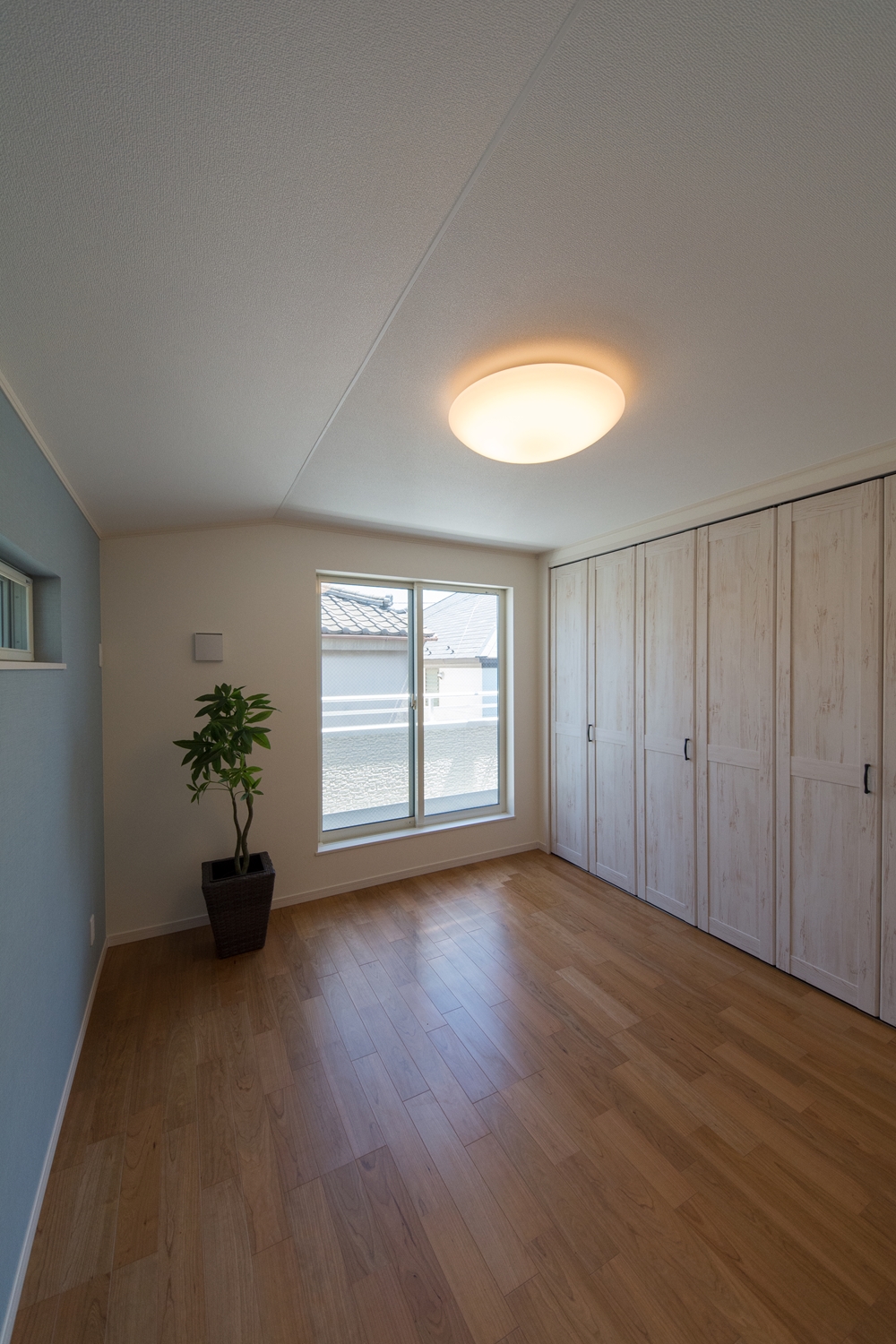 2F洋室/北欧スタイルの家具が良く似合うシャビーシックなホワイトの建具に淡いブルーグリーンのアクセントクロス。