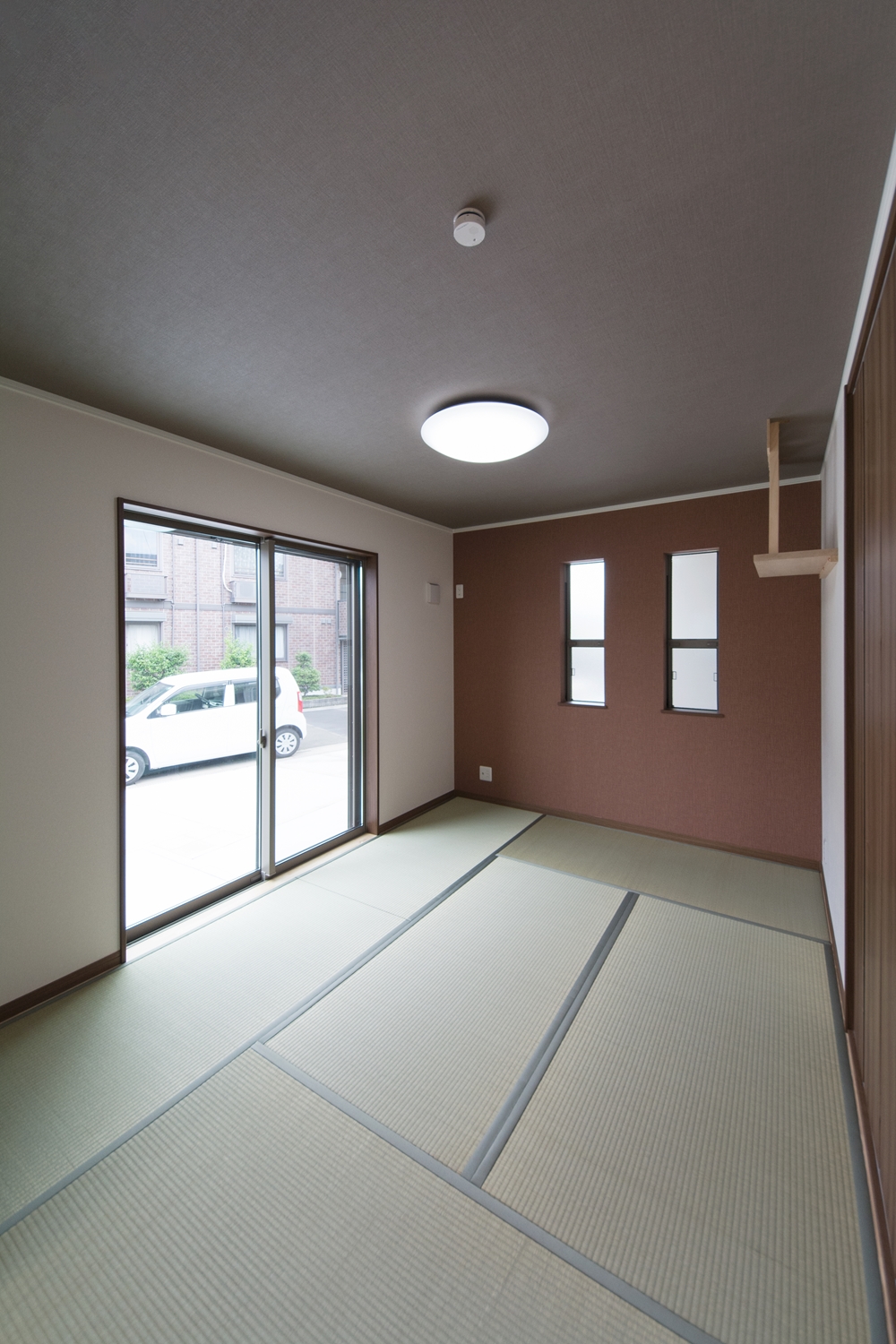 畳のさわやかなグリーンが空間を彩る1階畳敷きスペース。ブランのアクセントクロスがモダンな空間を演出。