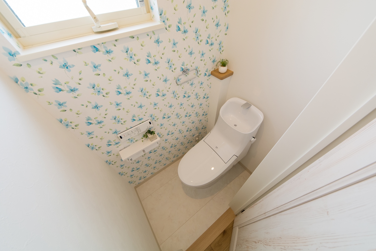 花の柄をモチーフにした白のクロスが、さり気なくエレガントに清潔感を演出する2階トイレ。