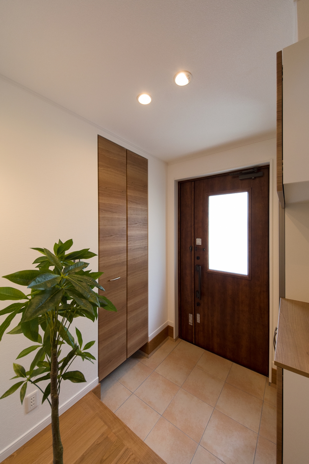 シューズクロークのある便利な玄関。木の温もり感じる暖かみのある空間に。