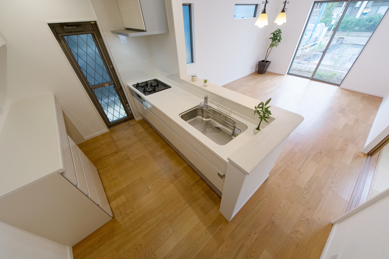 爽やかな白い木目調のキッチン扉。清潔感溢れるキッチンスペース。