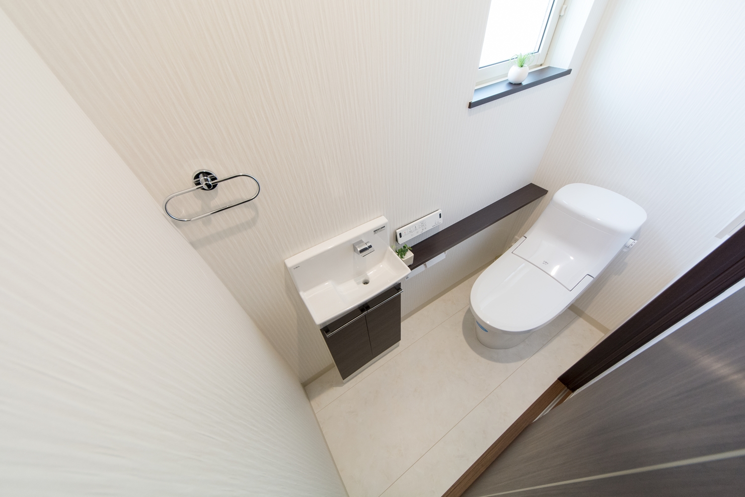白を基調とした清潔感のある1階トイレ。独立タイプの手洗いを設置しました。