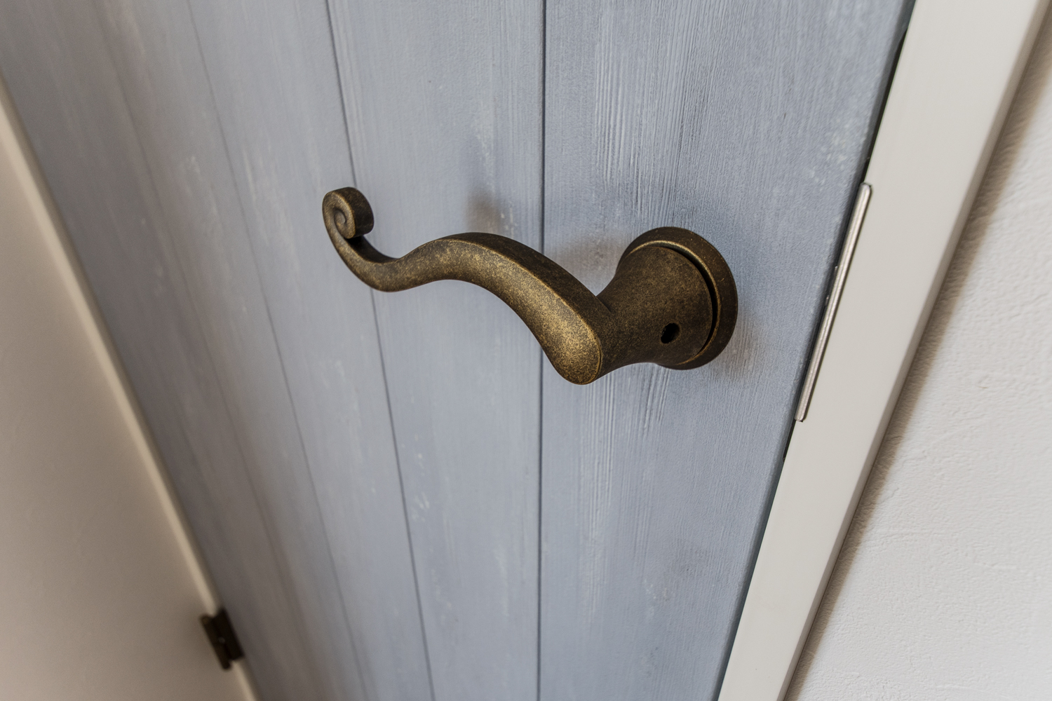 エイジング加工された、ブルーペイントのドア。ハンドルは、アンティーク調のゴールドを合わせ上質な印象に。