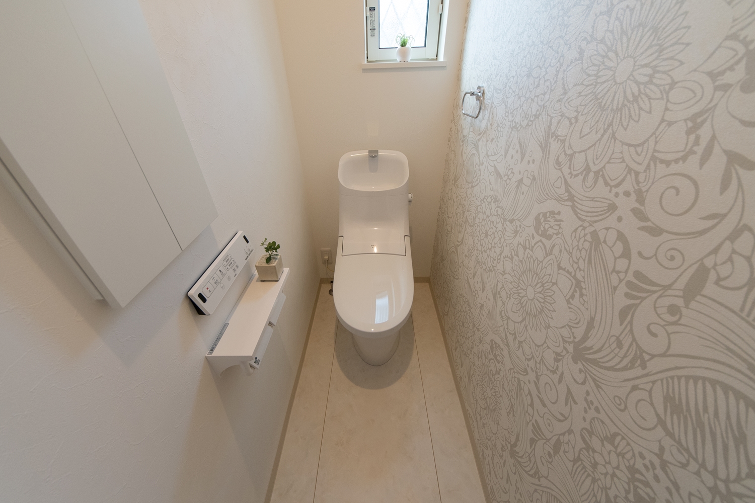 1階トイレ/花の柄をモチーフにした白のクロスが、エレガントな印象に。