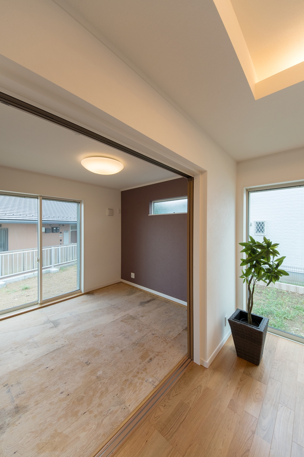 1階畳敷き洋室（写真は畳設置前）/横長の窓とブラウンのアクセントクロスがモダンな空間を演出。