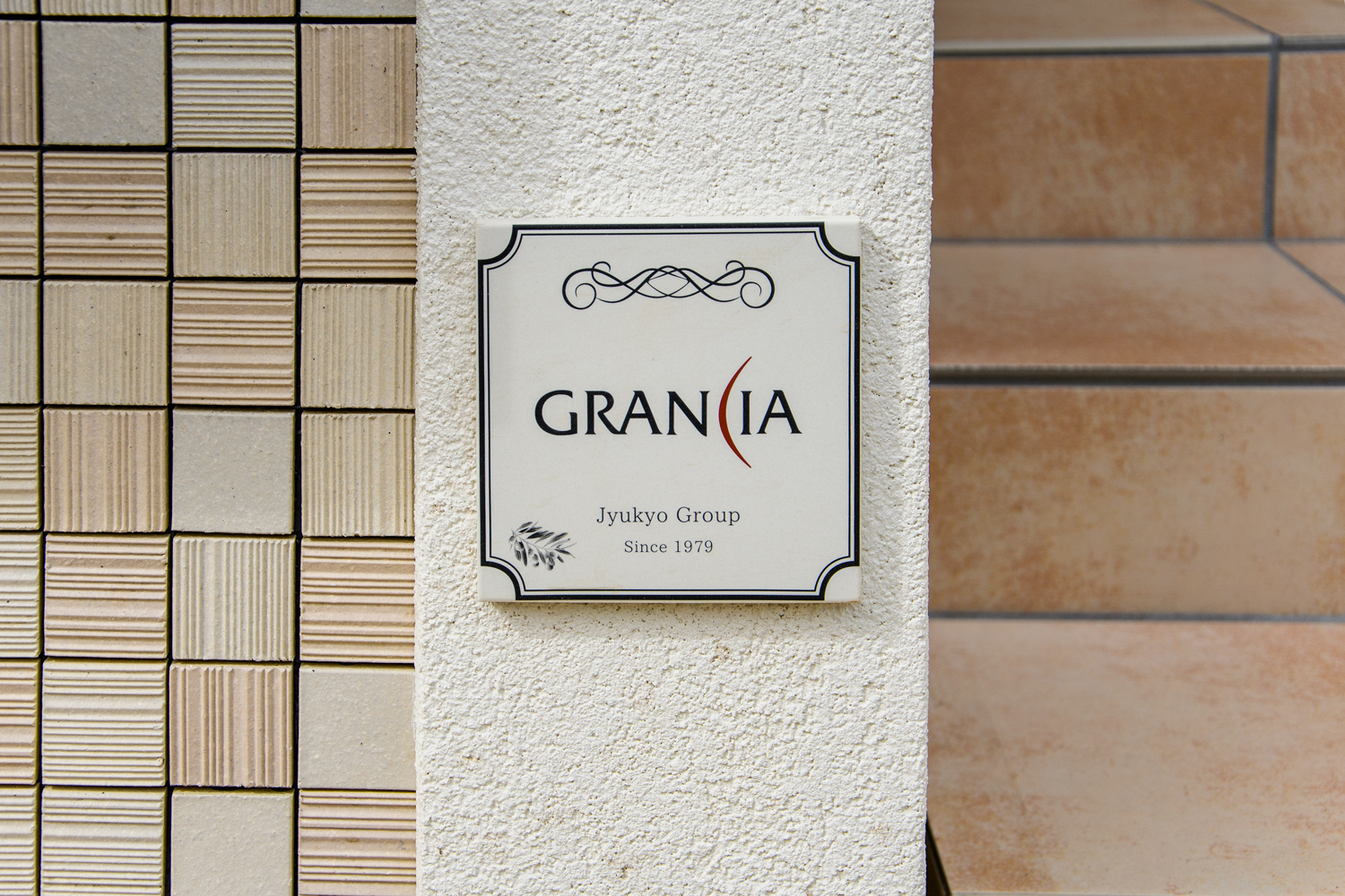 住協グループのブランド名「GRANCIA」のエンブレムをあしらった門柱。