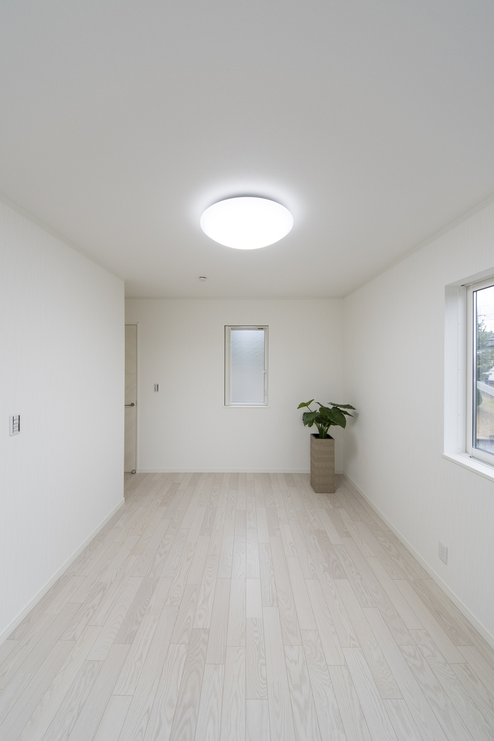 2階洋室／美しく繊細な木目アッシュホワイトのフローリングが窓から差し込む光を反射し、空間を優しく包み込みます。