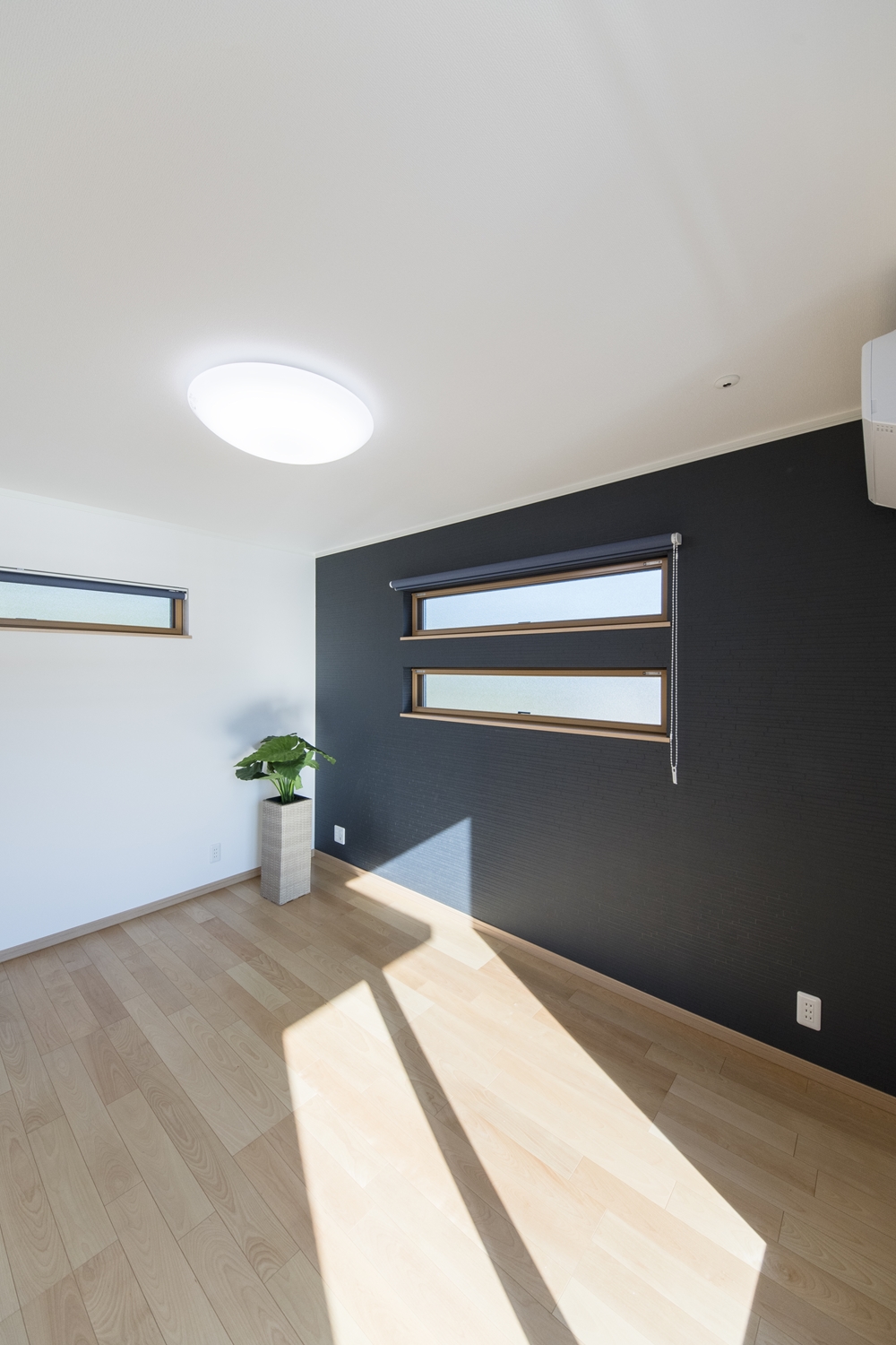 2階洋室／深みある濃紺色の壁紙と二連の横長窓のデザインがスタイリッシュな空間を演出。