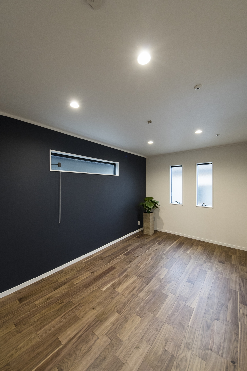 2階洋室／深みある濃紺色の壁紙をアクセントにした落ち着きのある空間。