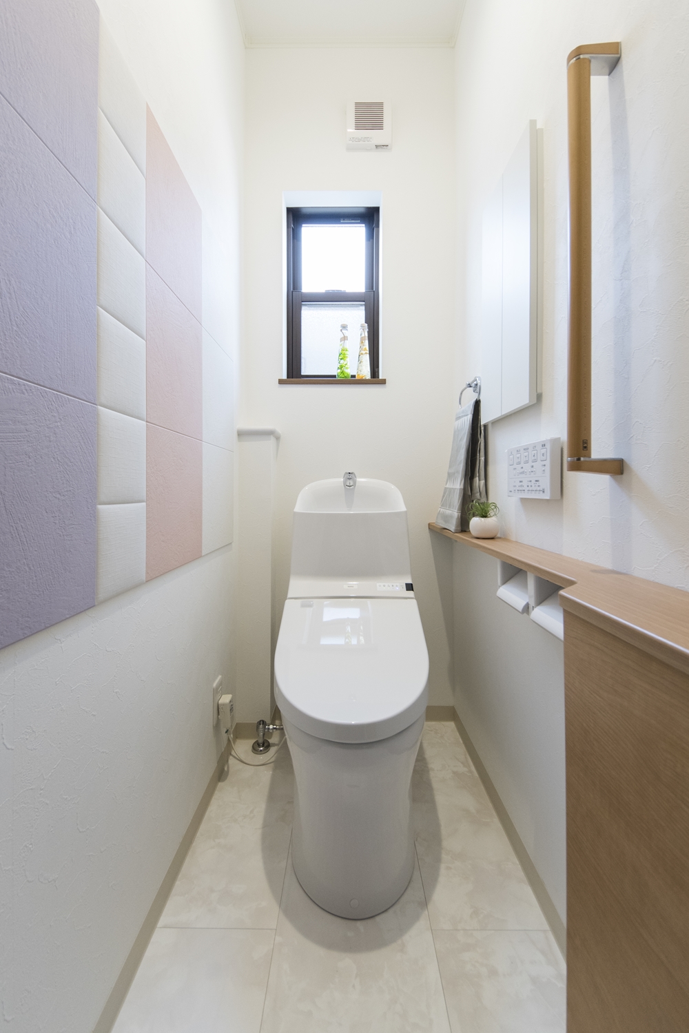 1Fトイレ(親世帯)／消臭・調湿効果のあるエコカラットタイルを施しました。パステルカラーを組み合わせた可愛らしいデザインです。