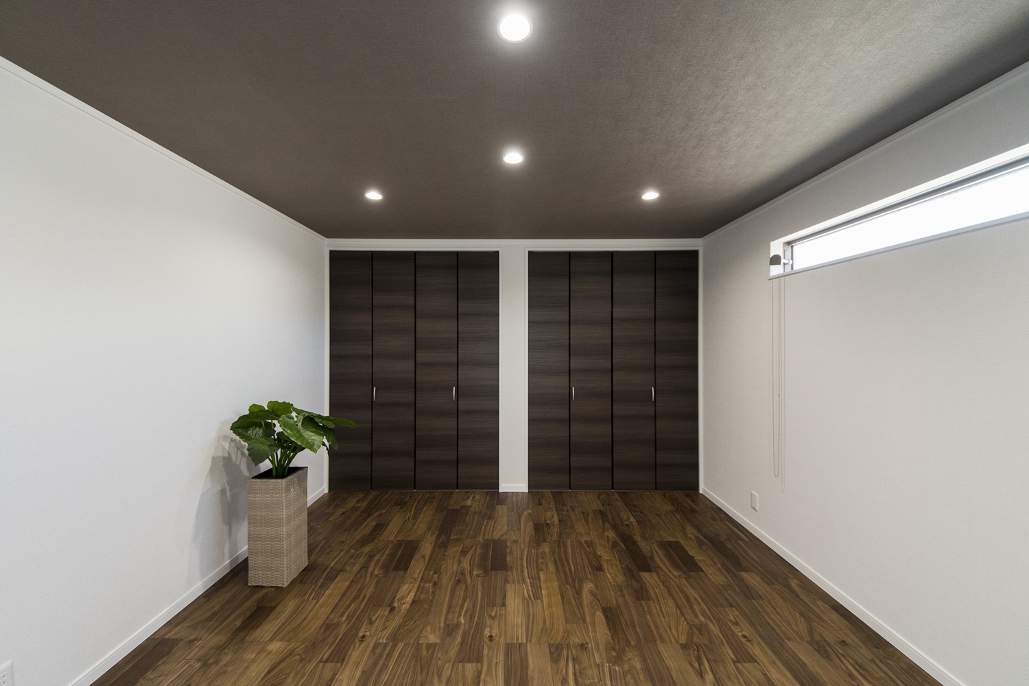 2階洋室／黒褐色の深みある色調ブラックウォルナットのフローリングに、シックな配色の天井や建具が、品の良い落ち着いた空間を演出します。