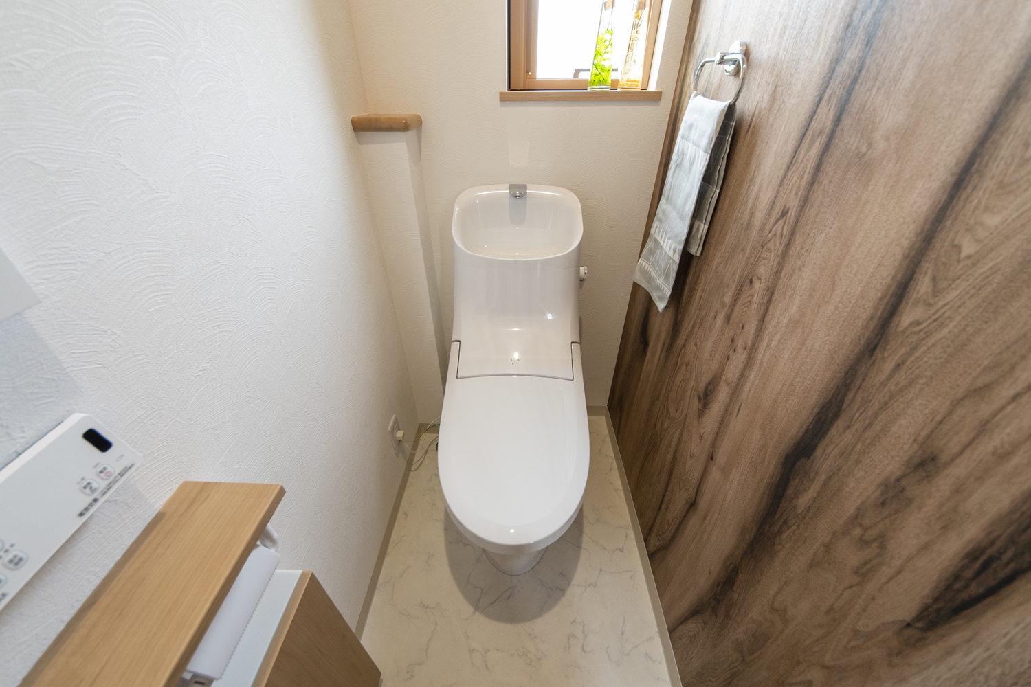 2階トイレ／ゆったりとした木目柄のアクセントクロスが心地良い穏やかな空間を演出します。