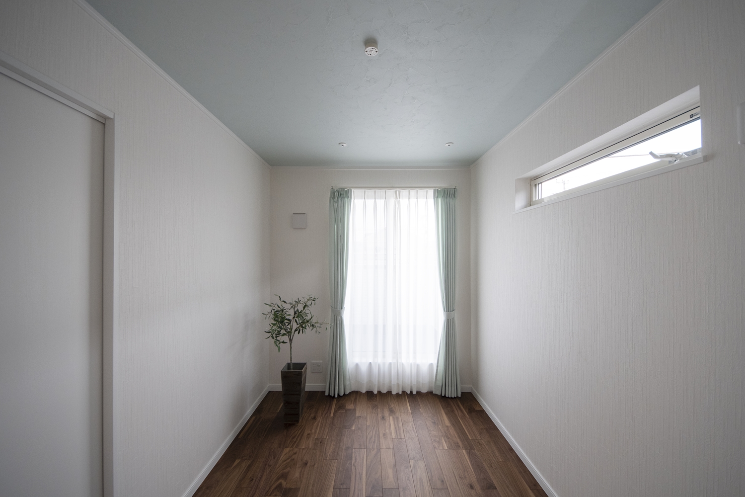 2階洋室／ブラックウォルナット独特の黒褐色の深みある色調が、白い壁と組み合わせるとより引き立ちます。天井には爽やかなブルーを配色しました。