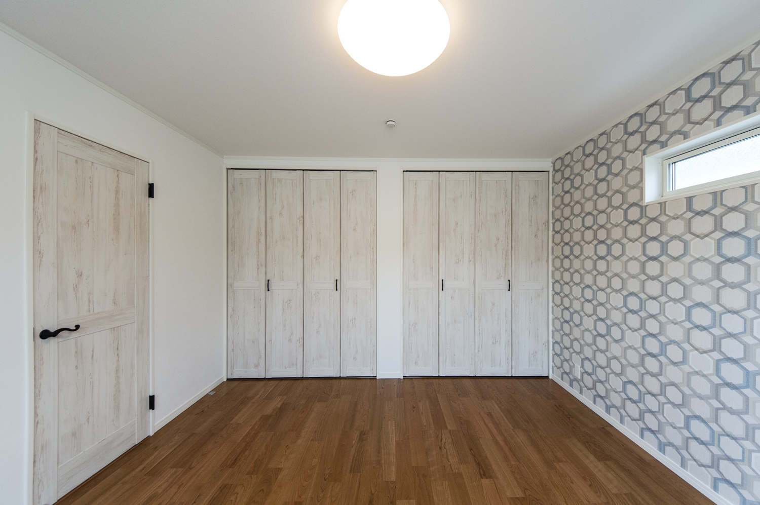 2階洋室／無垢の木に白ペンキを塗ったようなデザインの建具や、カジュアルなクロスをアクセントにした、おしゃれな空間。
