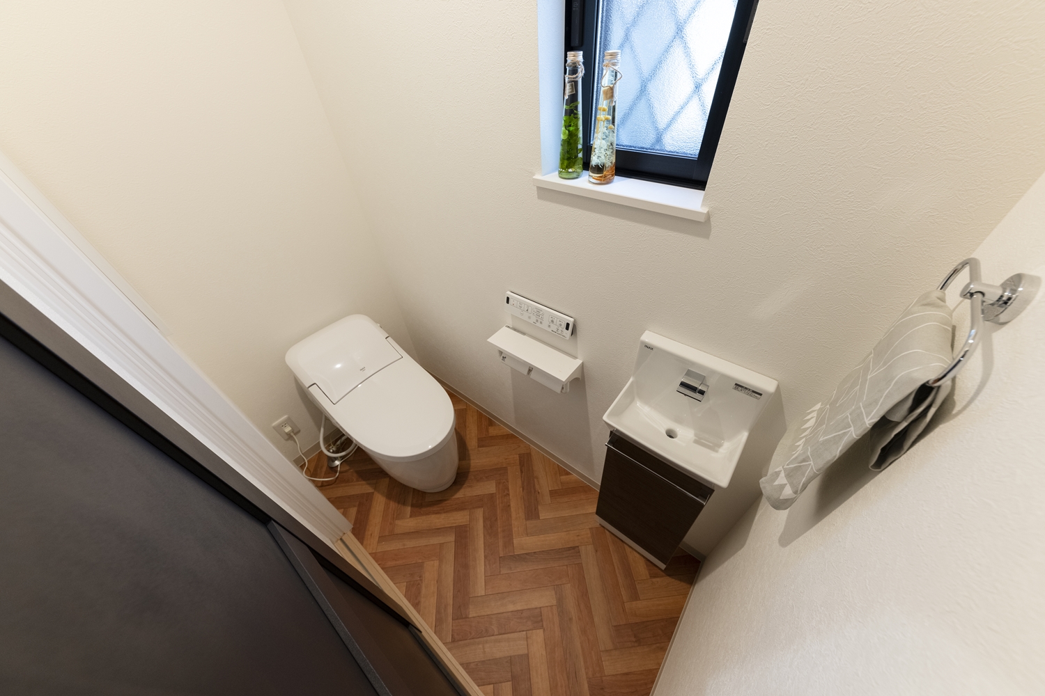明るい木目デザインの床が目を惹く1階トイレ。