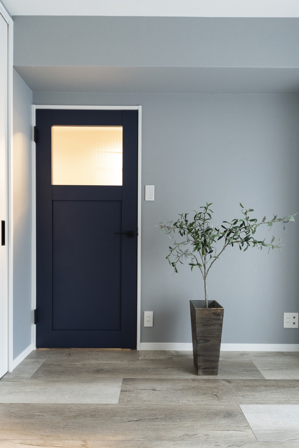 洋室／シャープなレトロ調ガラスと、ペンキをローラーで塗った様なマットな質感のネイビーブルーのドアが、グレーの壁に映えてお部屋のアクセントに。