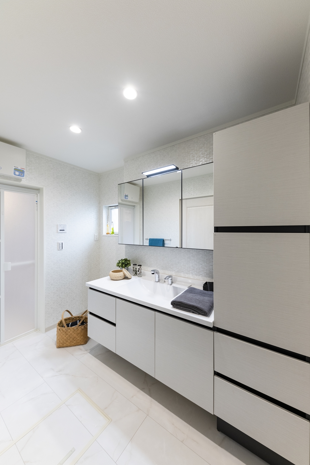 白を基調としたサニタリールーム。浮遊感のある、家具のようなキャビネットデザインに、美しい洗面ドレッサーが上質な空間を演出。