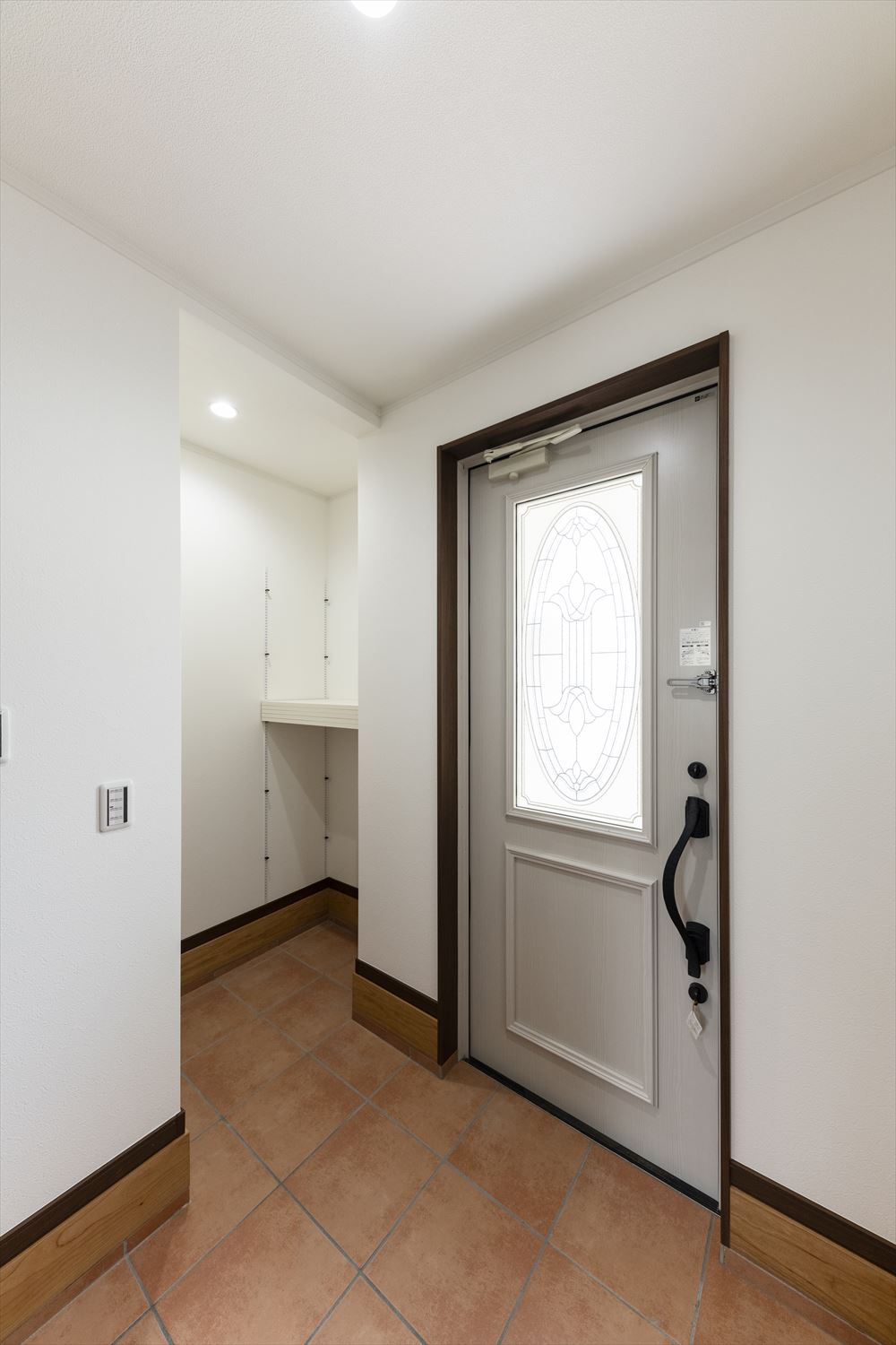 玄関ドアの大きな窓が明るく開放感のあるエントランス空間を演出。