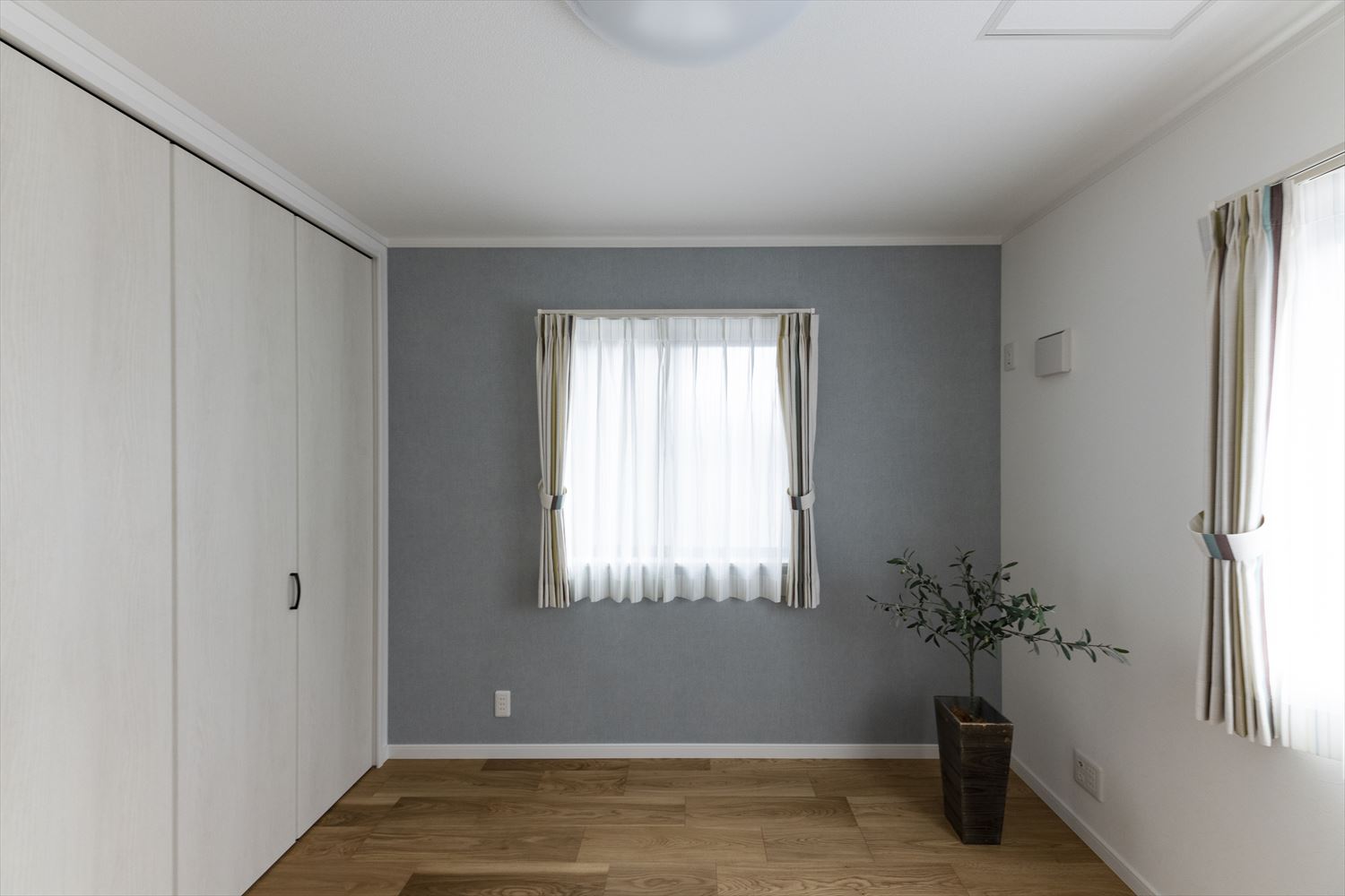 白×グレーの淡いコントラストがエレガントな印象の1階洋室。