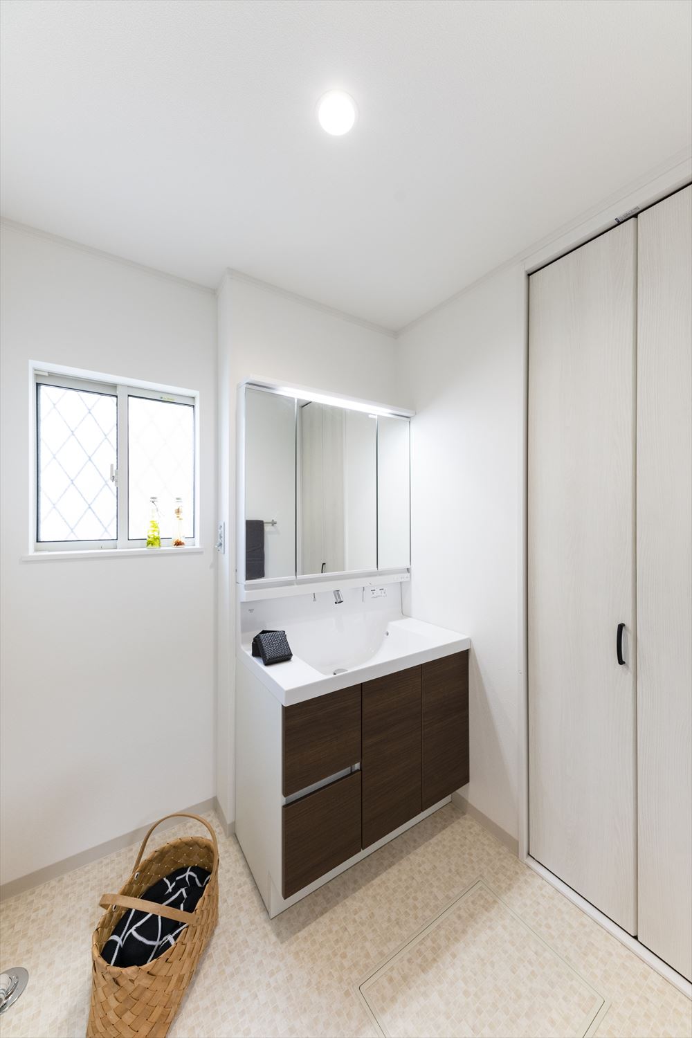 白を基調とした清潔感のあるサニタリールーム。タオルや洗剤等をたっぷり収納できるリネン棚や床下収納を設置し、すっきりとした空間に。
