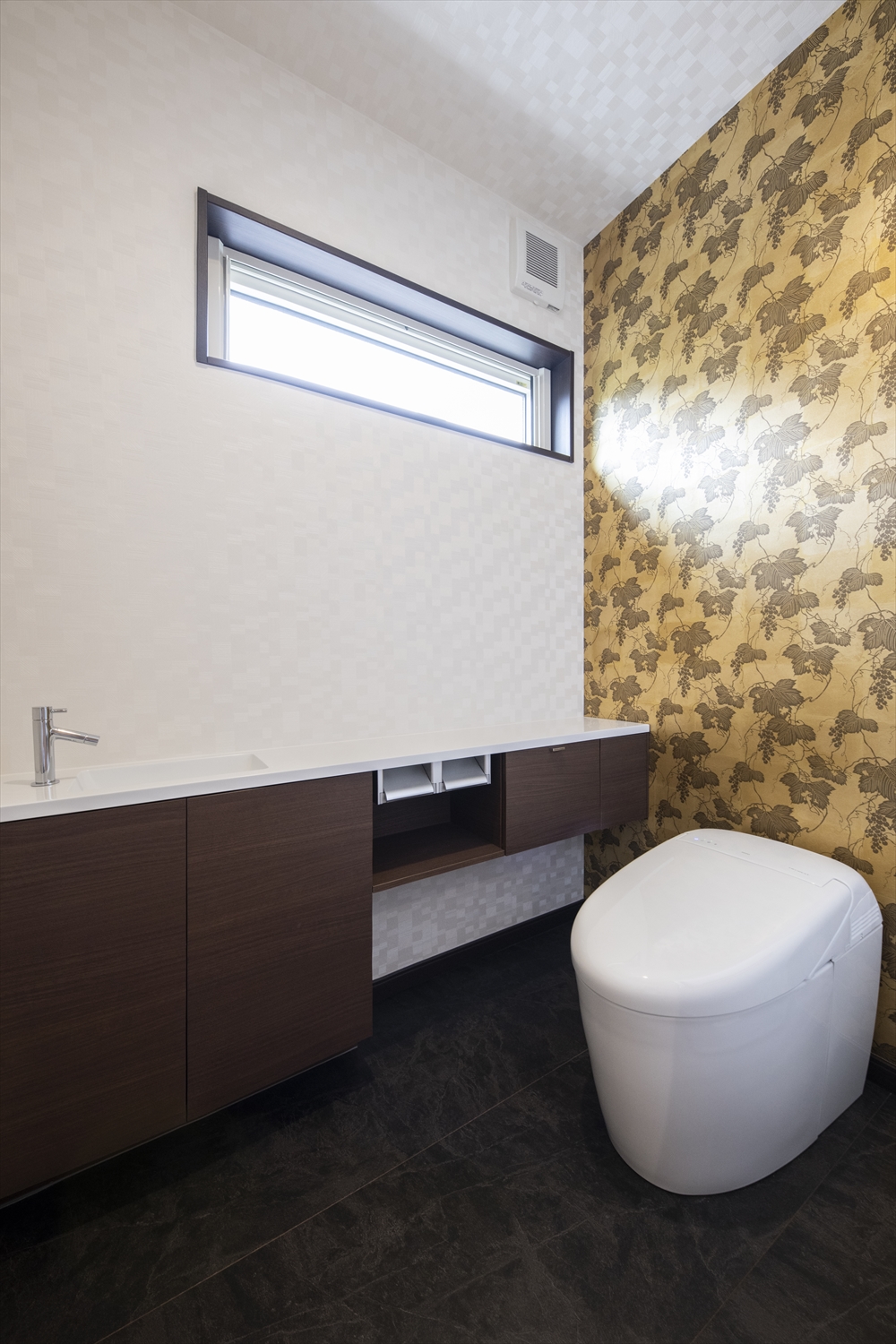 １階トイレ／コンパクトなタンクレストイレを採用して華やかなアクセントクロスで彩り高級感のある空間に